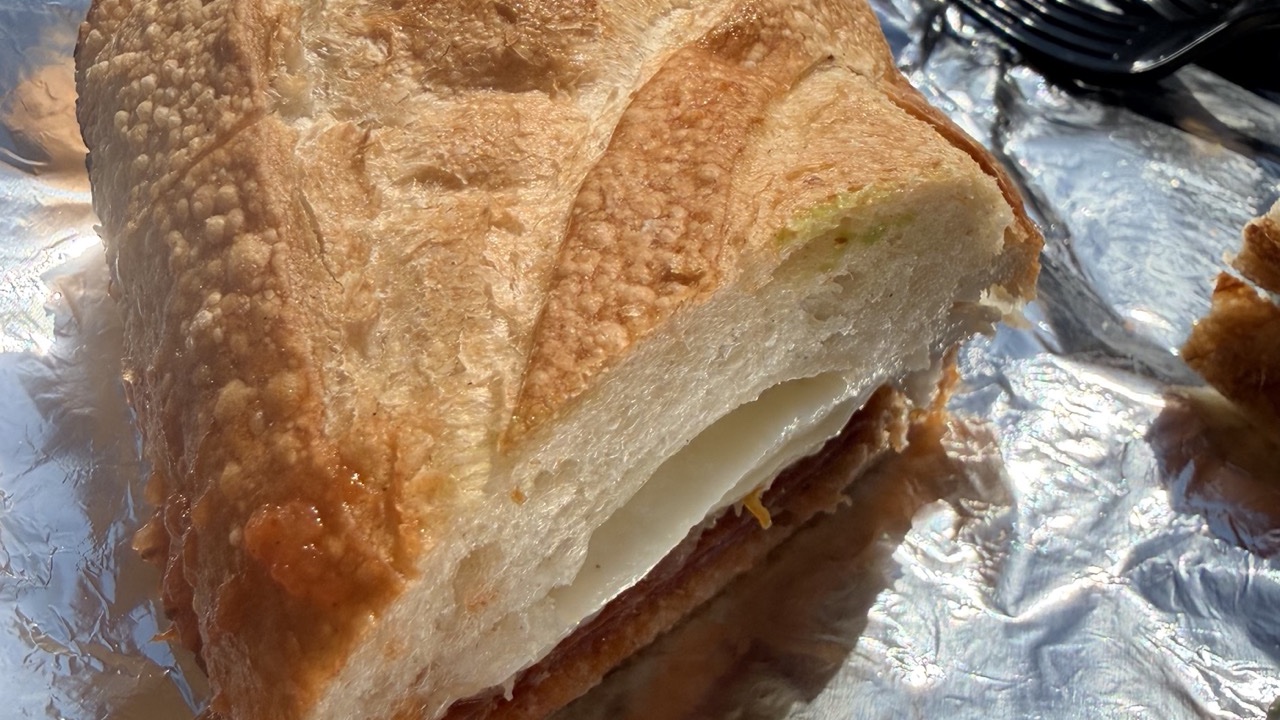 The Godfather's toasted baguette crust, sauce seeping through, cheese showing at the cut
