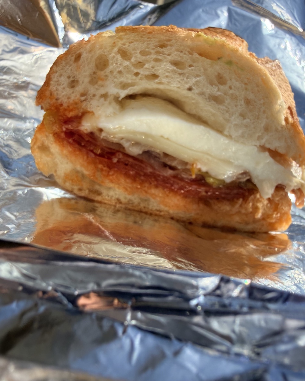 A half of the Godfather on foil — melted mozzarella and provolone over pepperoni and pizza sauce on toasted sourdough baguette